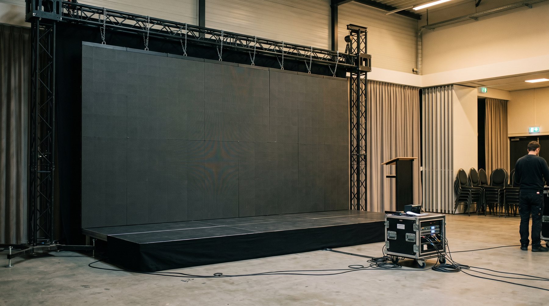 LED-wand op een podiumdek in een evenementenzaal, scherm uit tijdens de opbouw